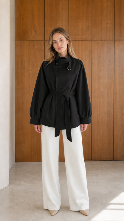 Model wearing black belted short trench jacket with high neck