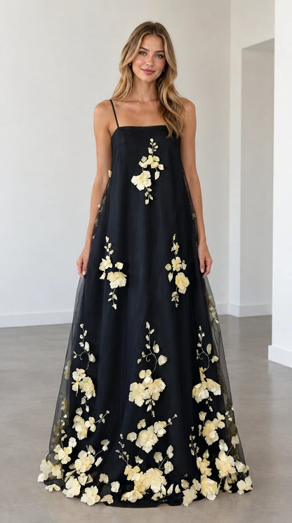 Model wearing black 3D floral applique spaghetti strap maxi dress