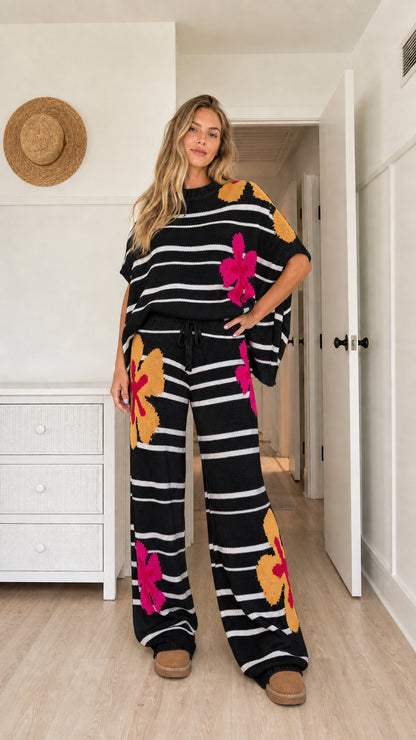 Model wearing black floral striped knit two-piece wide-leg lounge set