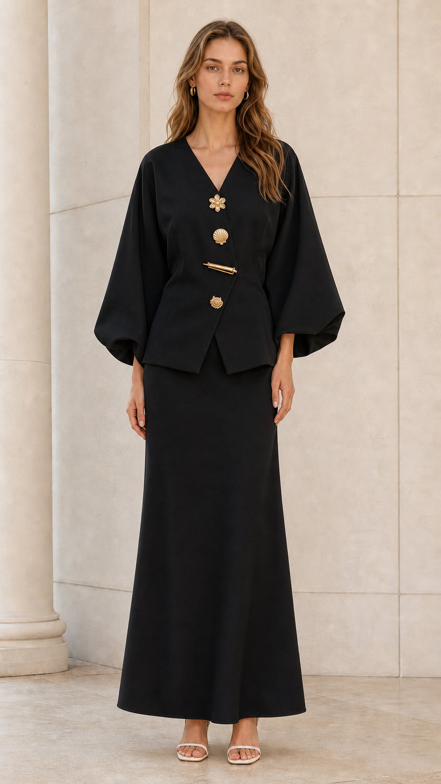 Front view of model wearing black lantern sleeve V-neck top and maxi skirt set with gold buttons