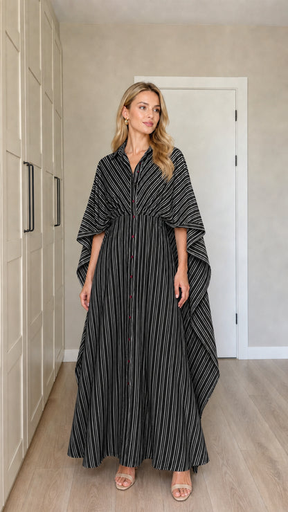 Front view of woman wearing black and white striped cape sleeve maxi dress