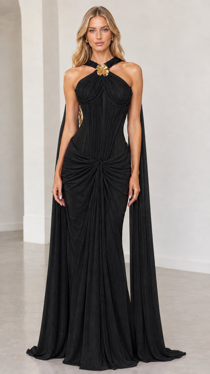 Front view of black halter corset maxi evening gown with shoulder cape panels
