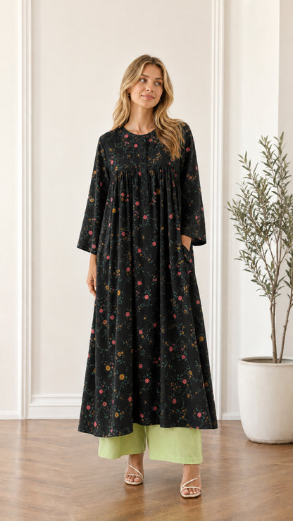 Front view of woman wearing black floral pleated maxi dress