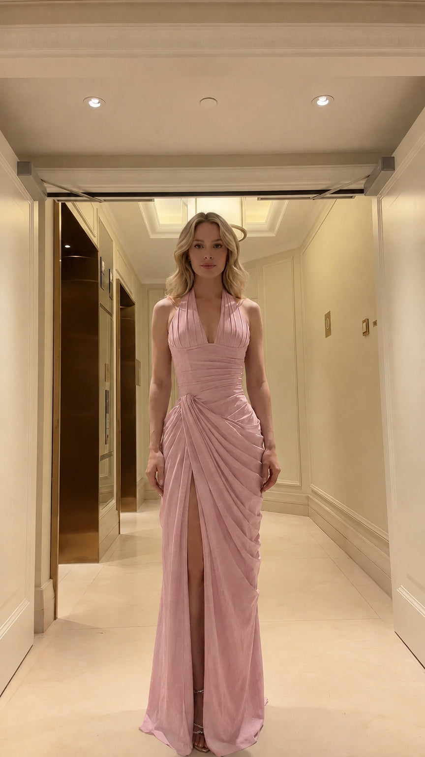 Front view of model wearing blush pink halter ruched evening maxi dress with slit