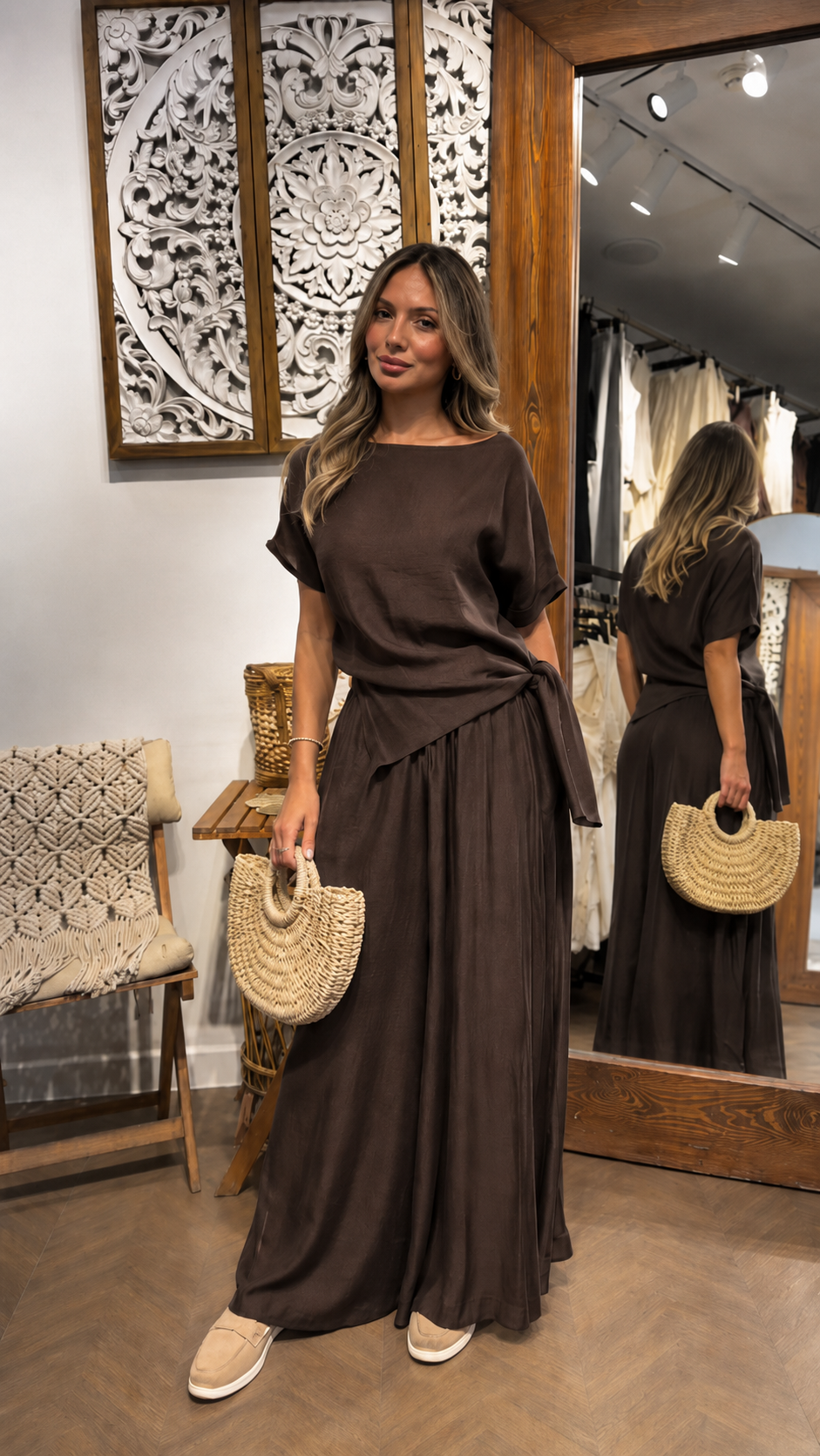 Woman wearing a chocolate brown draped waist maxi dress with a relaxed elegant fit