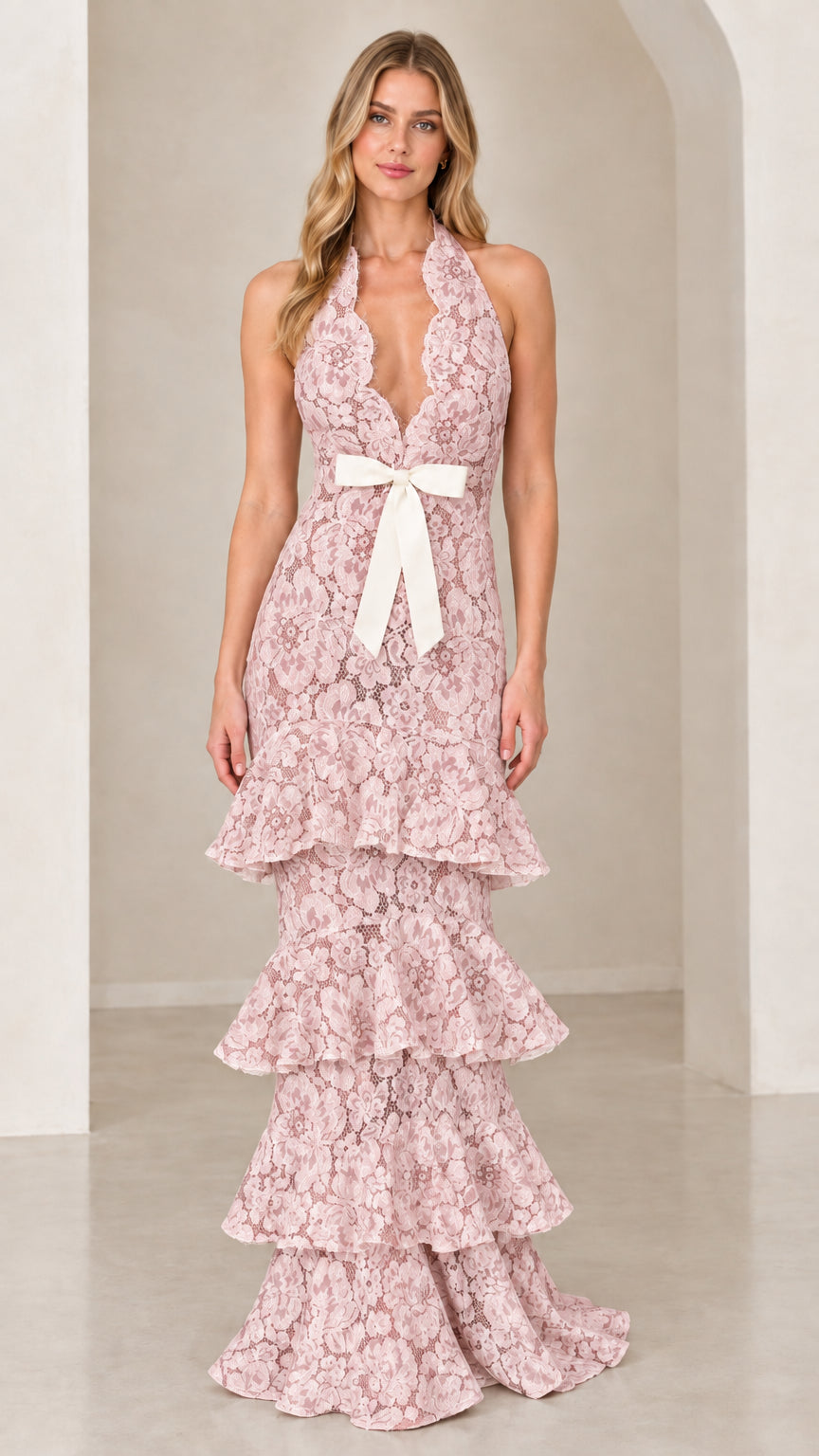 Front view of model wearing Pink halter tiered floral lace maxi dress with bow