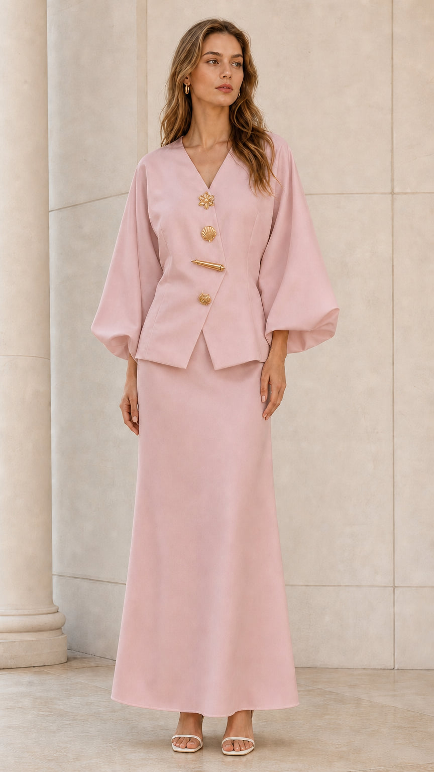 Front view of model wearing blush pink lantern sleeve top and maxi skirt set with gold buttons