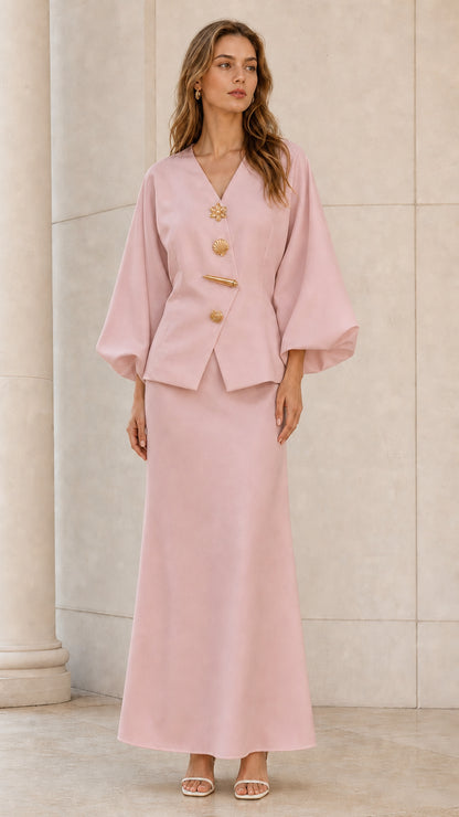 Front view of model wearing blush pink lantern sleeve top and maxi skirt set with gold buttons
