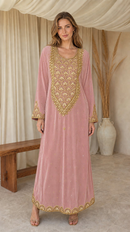 Model posing in dusty pink embroidered velvet maxi kaftan dress