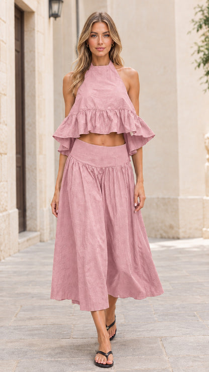 Front full-length view of model wearing dusty pink halter crop top and midi skirt set