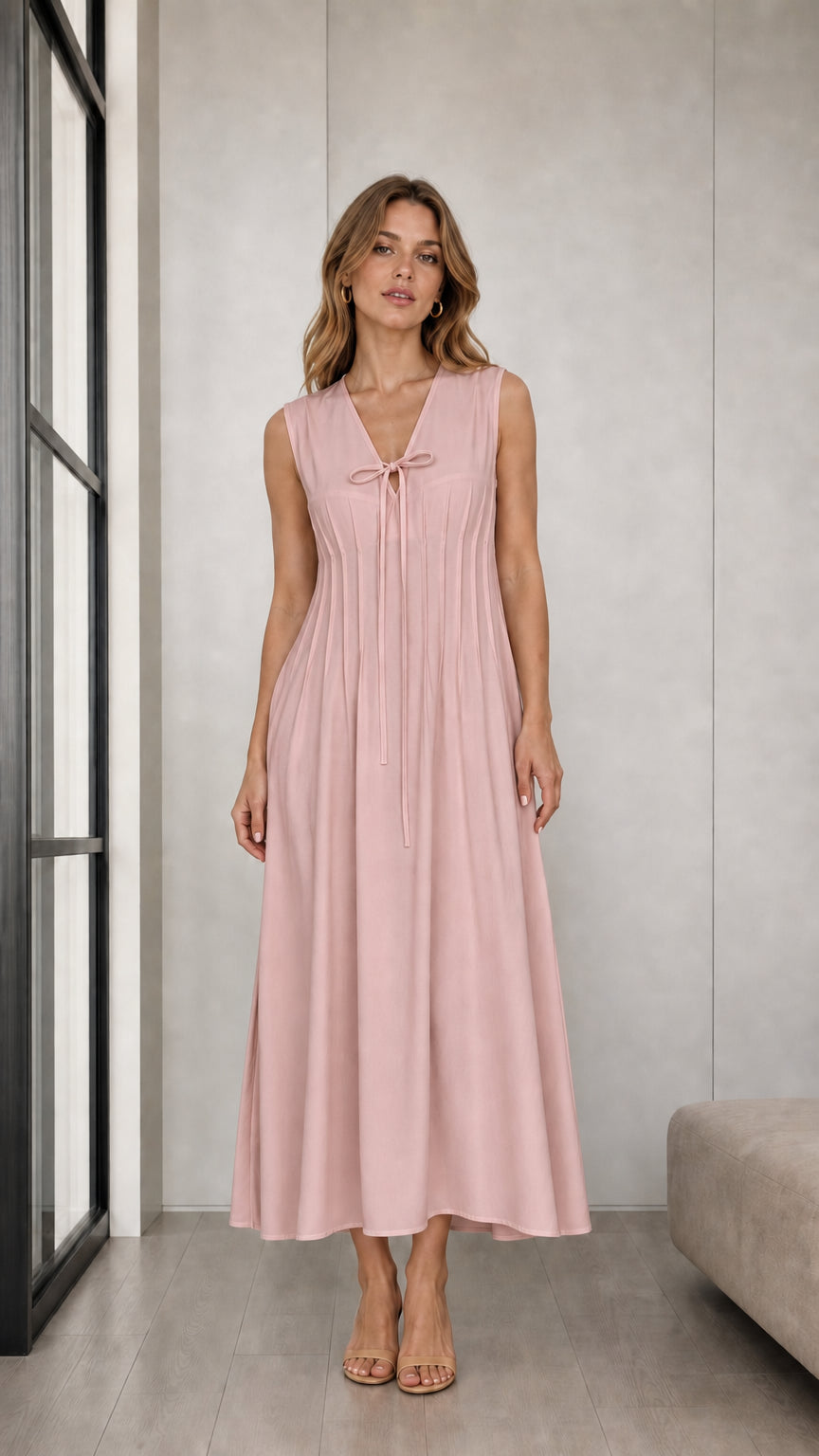 Front view of woman wearing Dusty Pink sleeveless pleated tie-neck midi dress