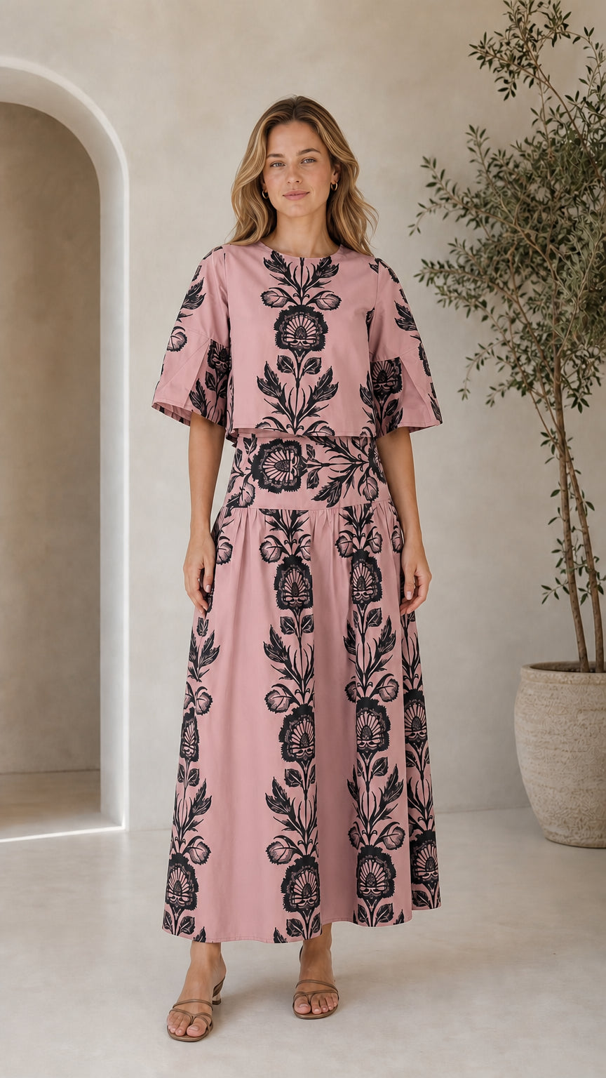 Woman wearing dusty pink floral print matching crop top and maxi skirt set