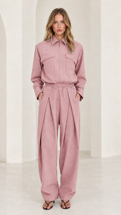 Front view of model wearing dusty pink long sleeve pleated wide-leg jumpsuit