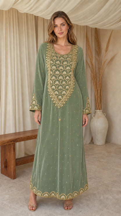 Model posing in sage green embroidered velvet maxi kaftan dress