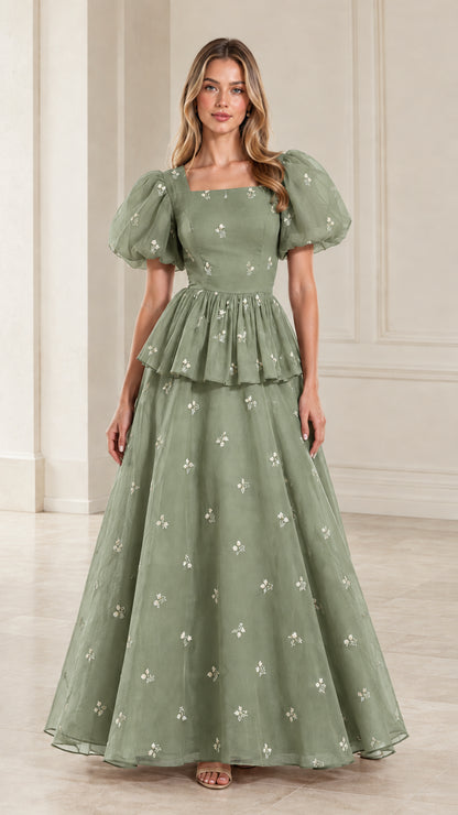 Full-length view of woman wearing sage green embroidered puff sleeve peplum maxi gown