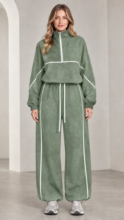 Front view of woman wearing sage green quarter-zip tracksuit set with white contrast piping