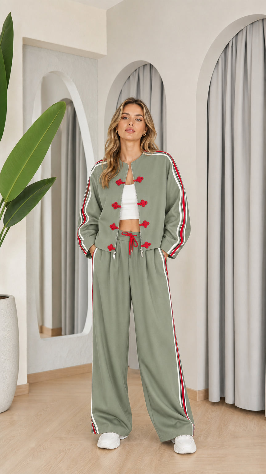 Model wearing sage green two-piece tracksuit set with red accents