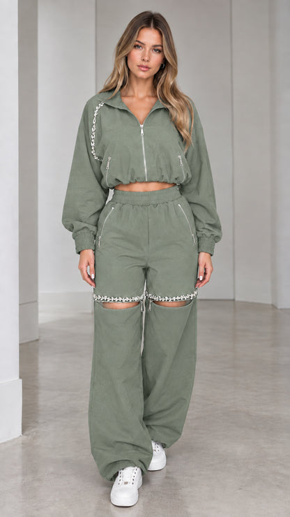 Model wearing sage green cropped zip jacket and rhinestone cut-out wide leg pants set