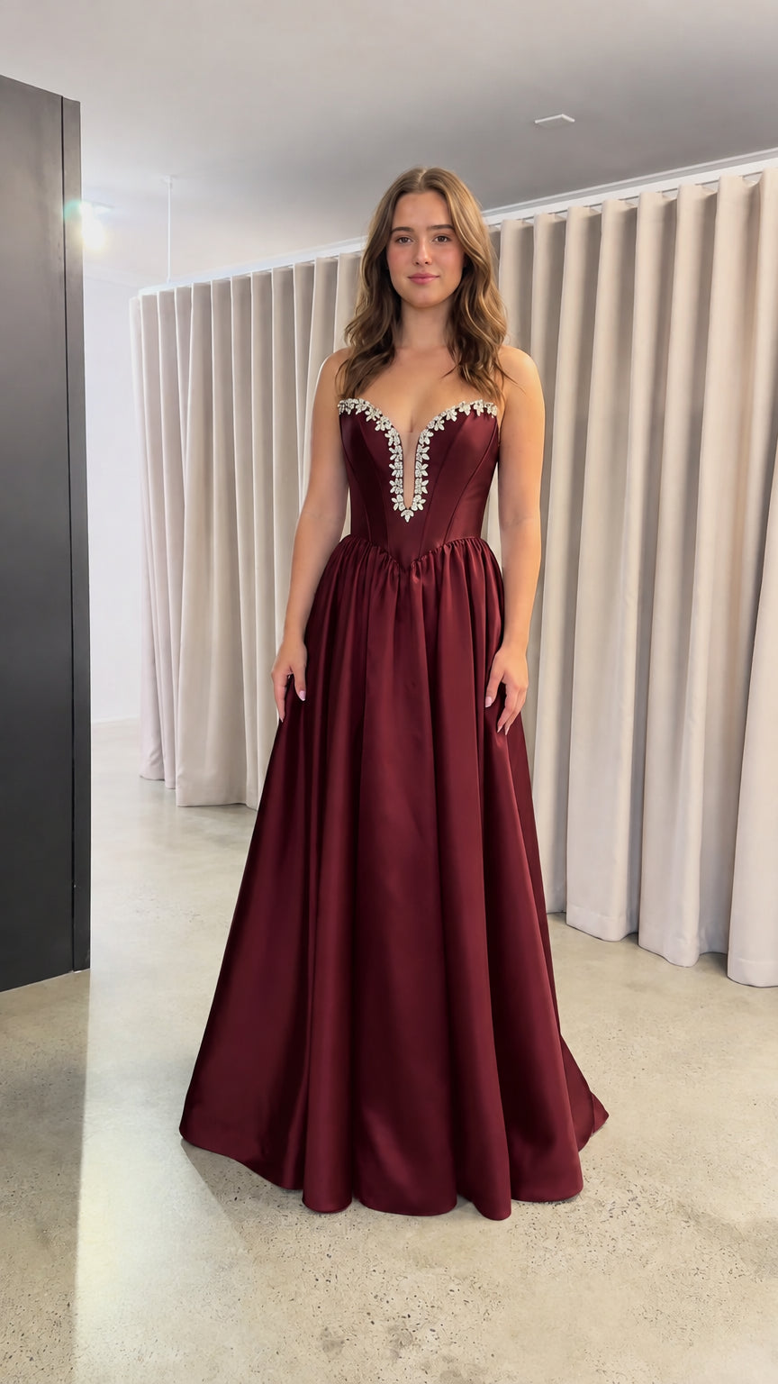 Front view of burgundy red strapless satin evening dress with crystal trim