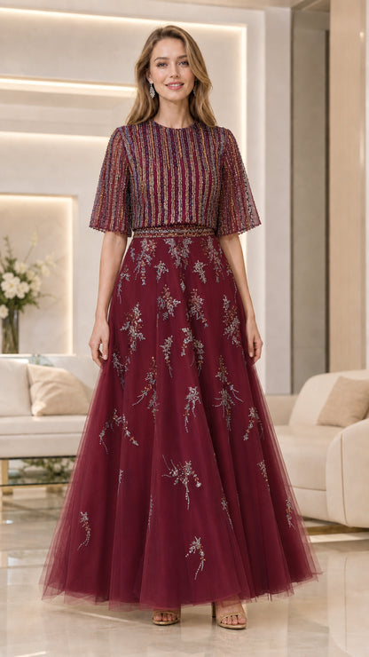 Model wearing burgundy beaded flutter-sleeve tulle evening gown