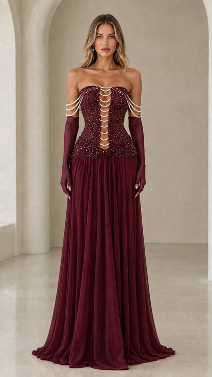 Model wearing burgundy strapless pearl beaded corset maxi evening gown with gloves