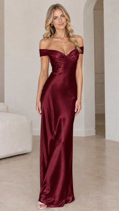 Front view of woman wearing burgundy off-the-shoulder satin maxi gown