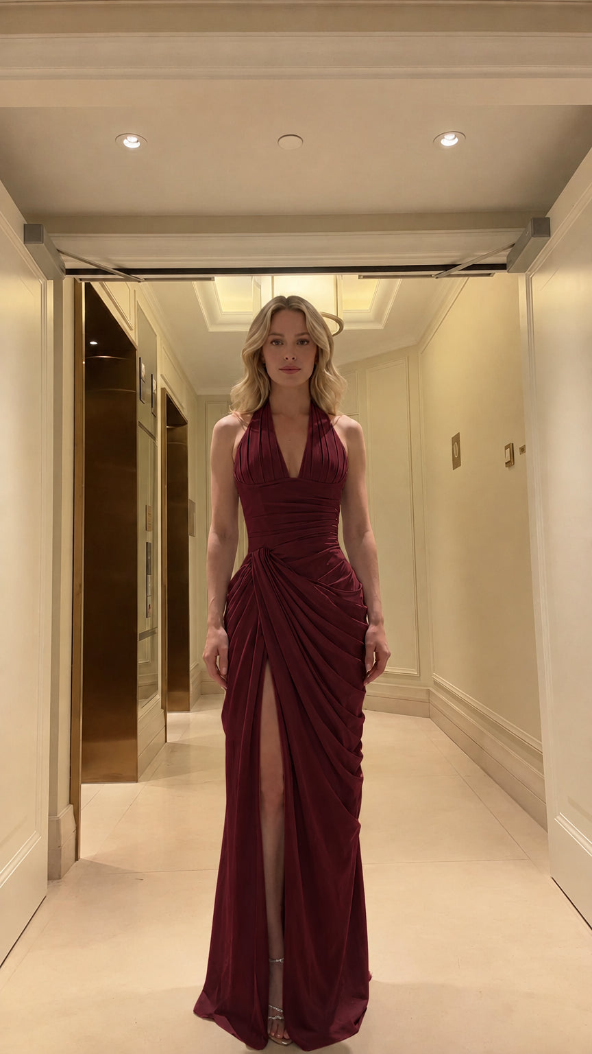 Front view of model wearing rich burgundy halter ruched maxi formal gown