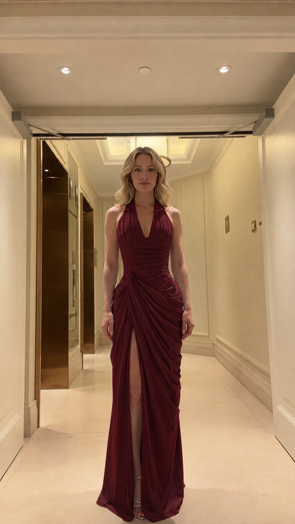 Front view of model wearing rich burgundy halter ruched maxi formal gown