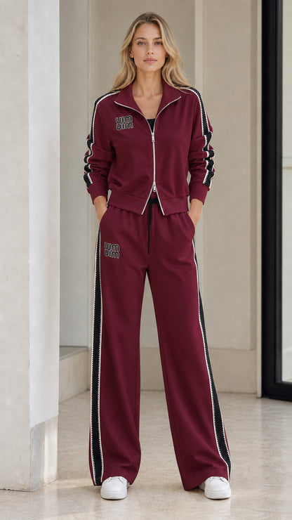 Model wearing Burgundy zip-up jacket and wide-leg track pants two-piece set
