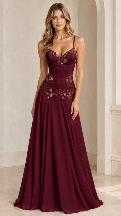 Model wearing burgundy red formal evening gown with beaded corset bodice and flowy skirt
