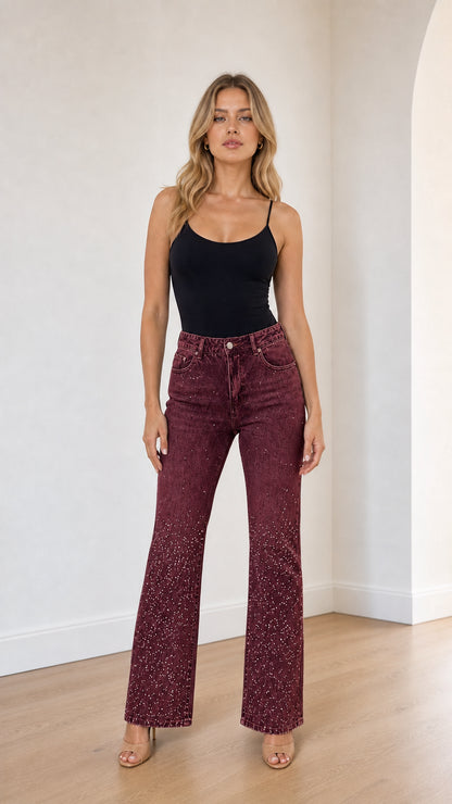 Full front view of model wearing burgundy wine rhinestone studded flare jeans