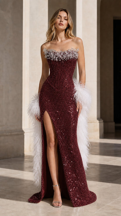 Model wearing burgundy wine strapless sequin formal gown with high slit