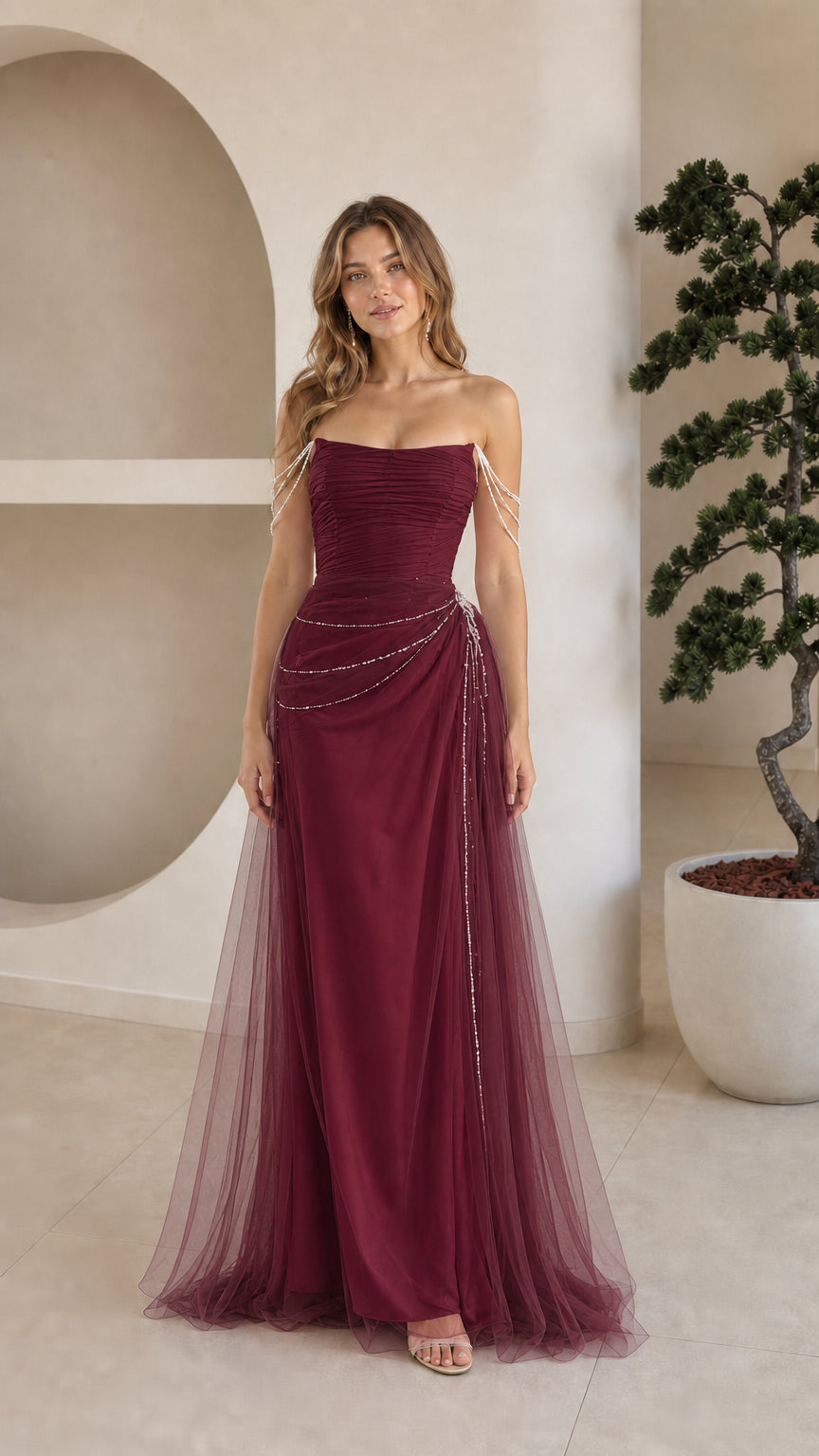 Front view of model wearing burgundy red strapless beaded tulle evening gown