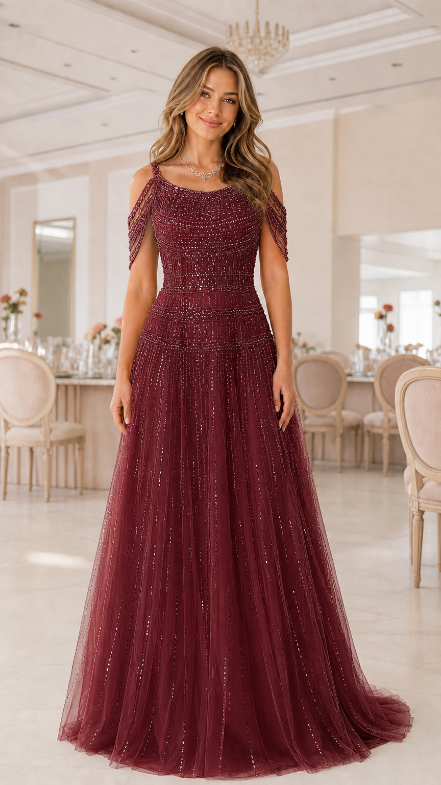 Full-length front view of model in deep burgundy beaded cold-shoulder gown