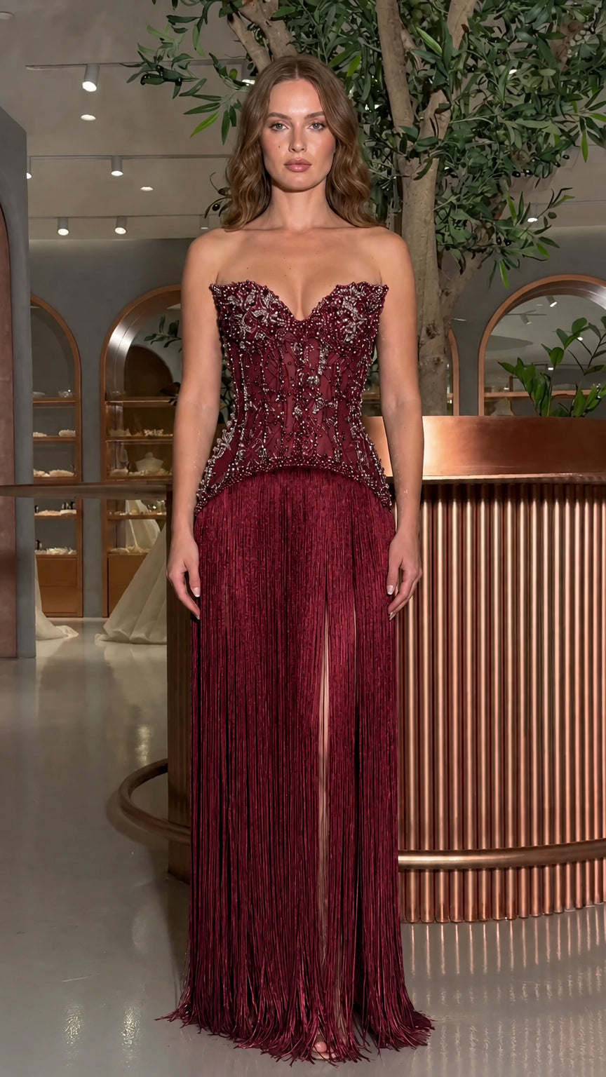 Front view of model wearing the burgundy beaded corset fringe evening gown