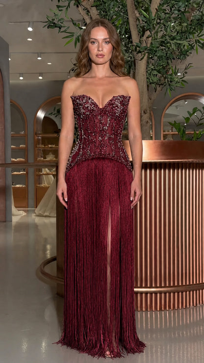 Front view of model wearing the burgundy beaded corset fringe evening gown
