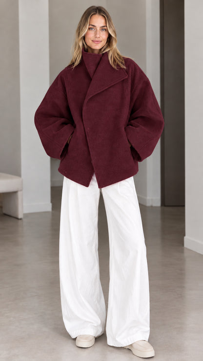 Model wearing deep burgundy wine asymmetrical snap-front short coat