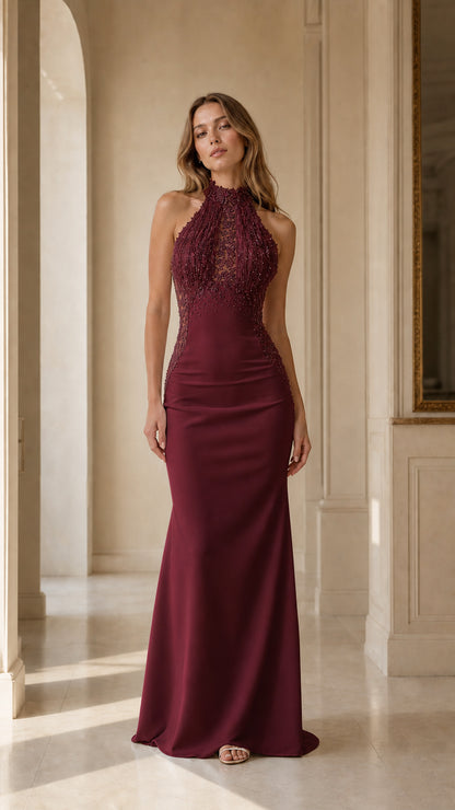 Front view of woman wearing burgundy halter beaded fringe mermaid evening gown