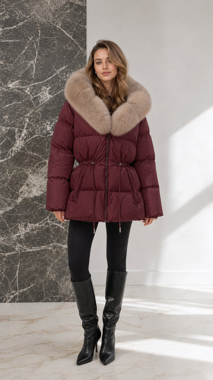 Full-body view of model wearing burgundy wine-red quilted puffer coat with fur trim