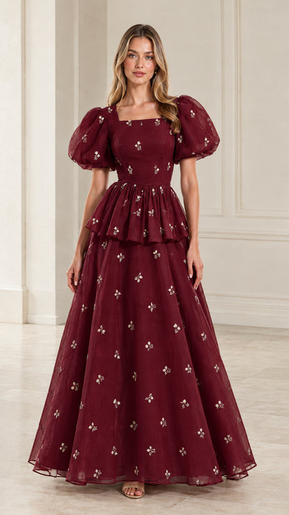 Full-length view of woman wearing rich burgundy embroidered puff sleeve evening dress