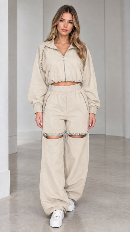 Model wearing beige cream cropped zip jacket and rhinestone cut-out wide leg pants set