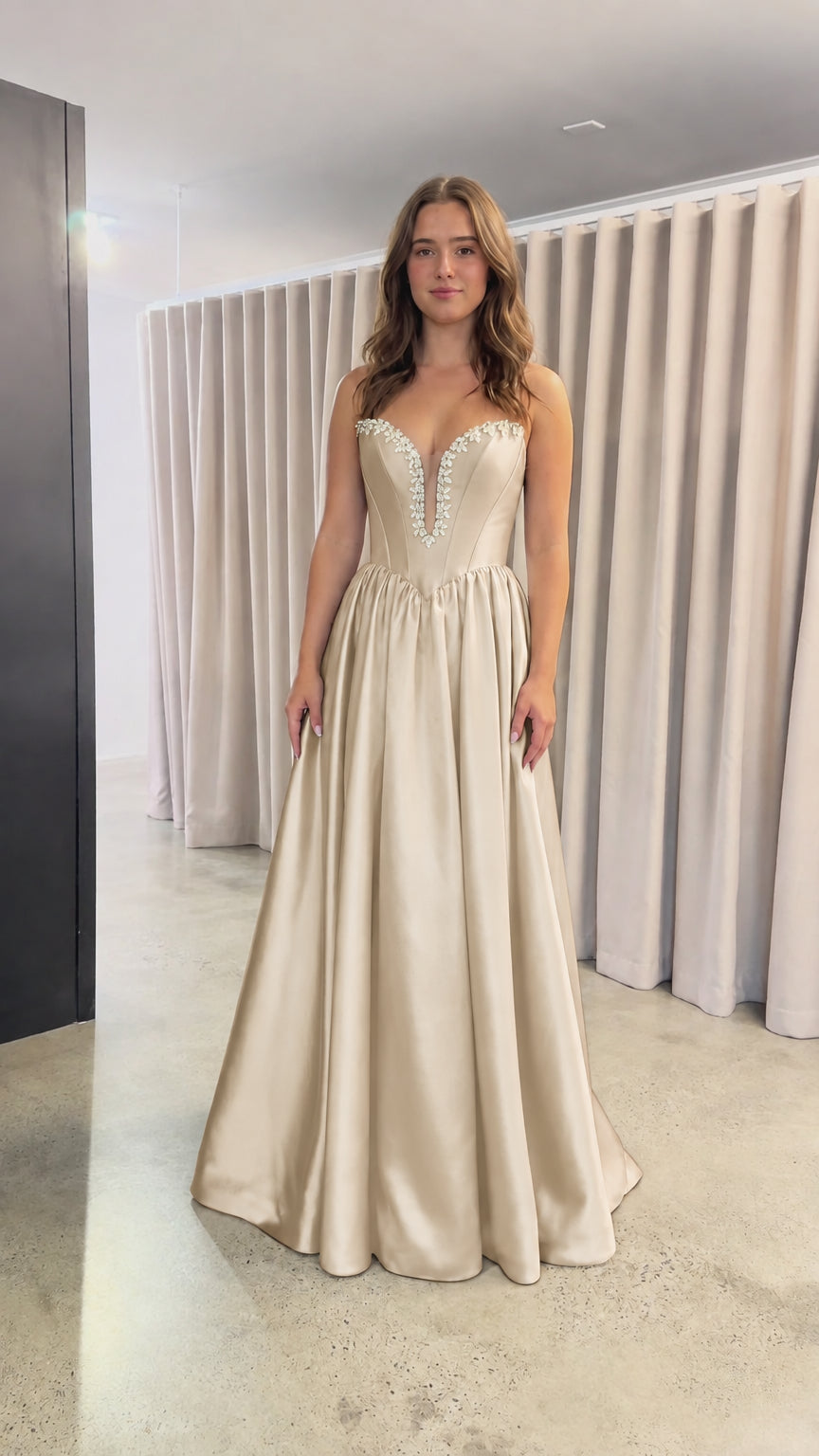 Front view of champagne gold strapless satin evening dress with crystal trim
