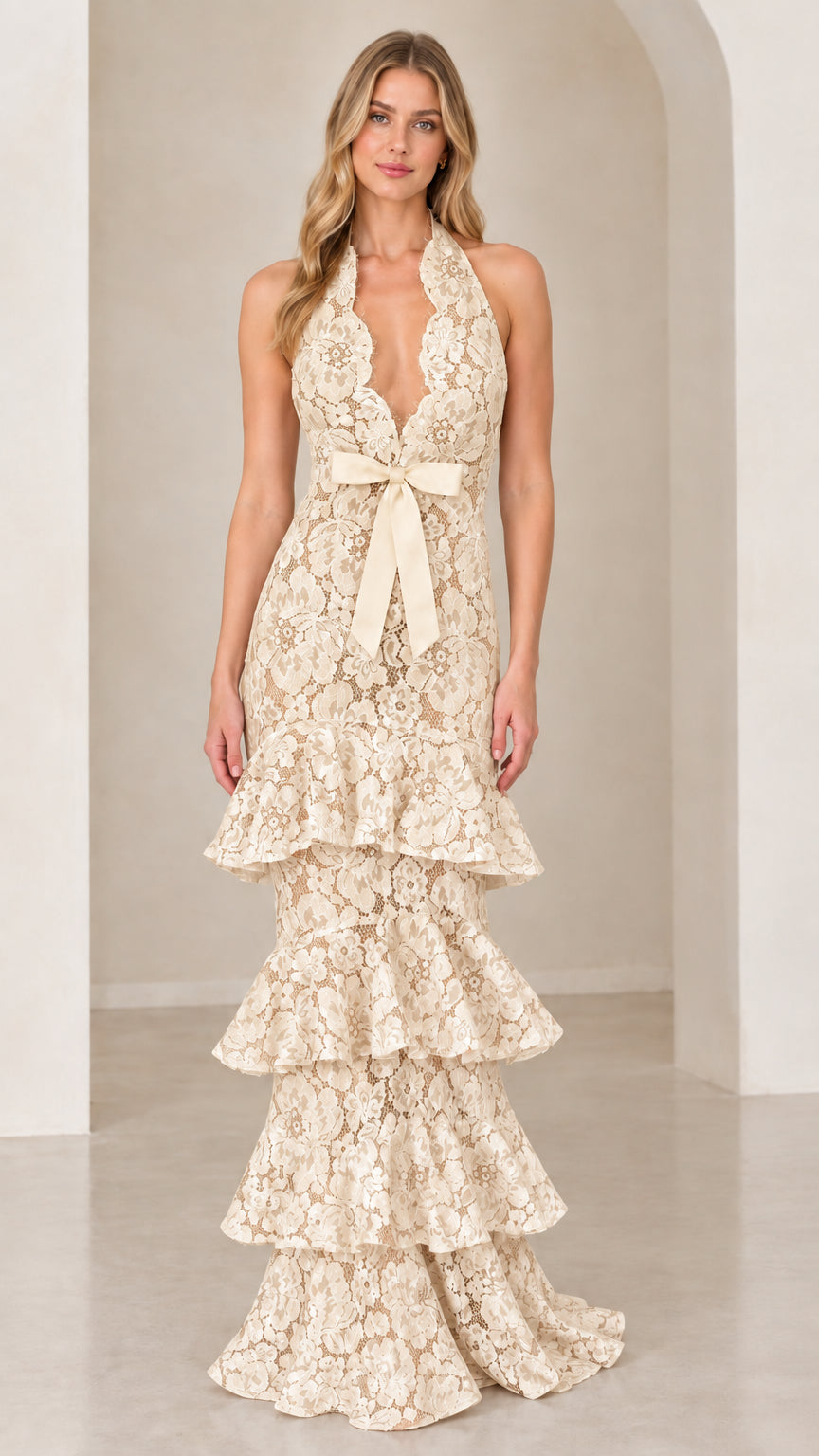 Front view of model wearing Champagne cream halter tiered floral lace evening gown